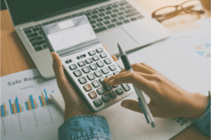 A person using a calculator on a desk.