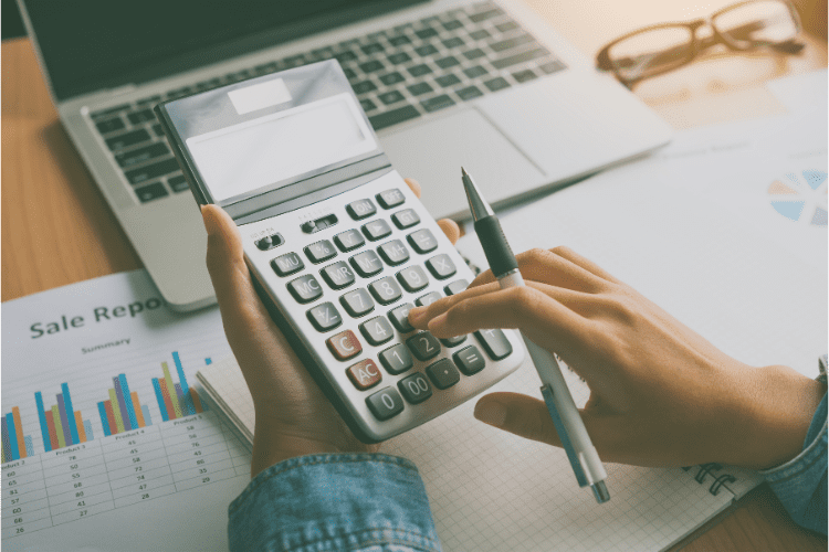 A person using a calculator on a desk.